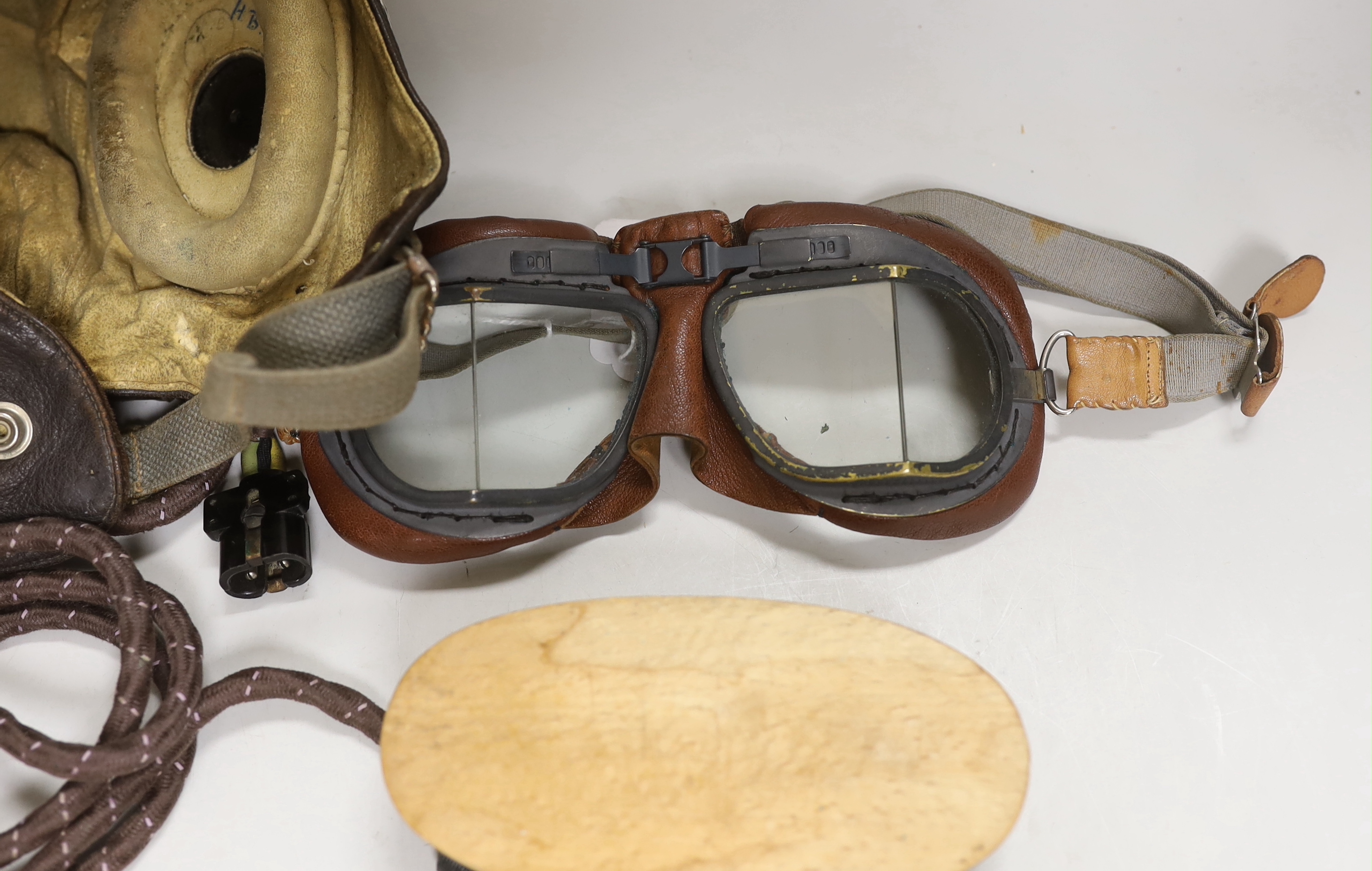 A WWII RAF flying helmet with speaker earpieces and original cables and plugs, Ref No.10A/13466, initialled in pen ‘HB’ for H. Brown 1320701, together with flying goggles and a contemporary clothes brush, provenance - by